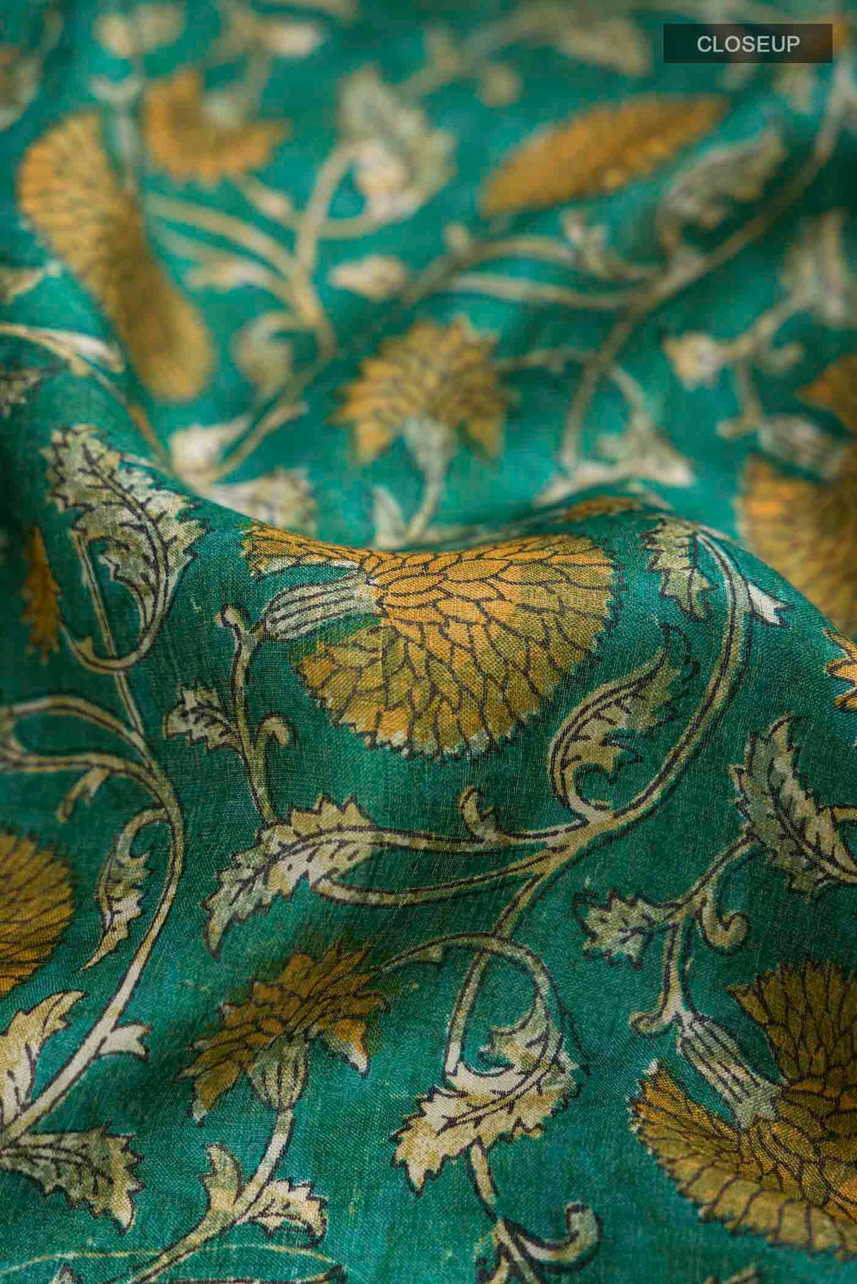Close up of Green Bhagalpuri Tussar Silk Saree with Printed design on the body and Zari Border displaying folds