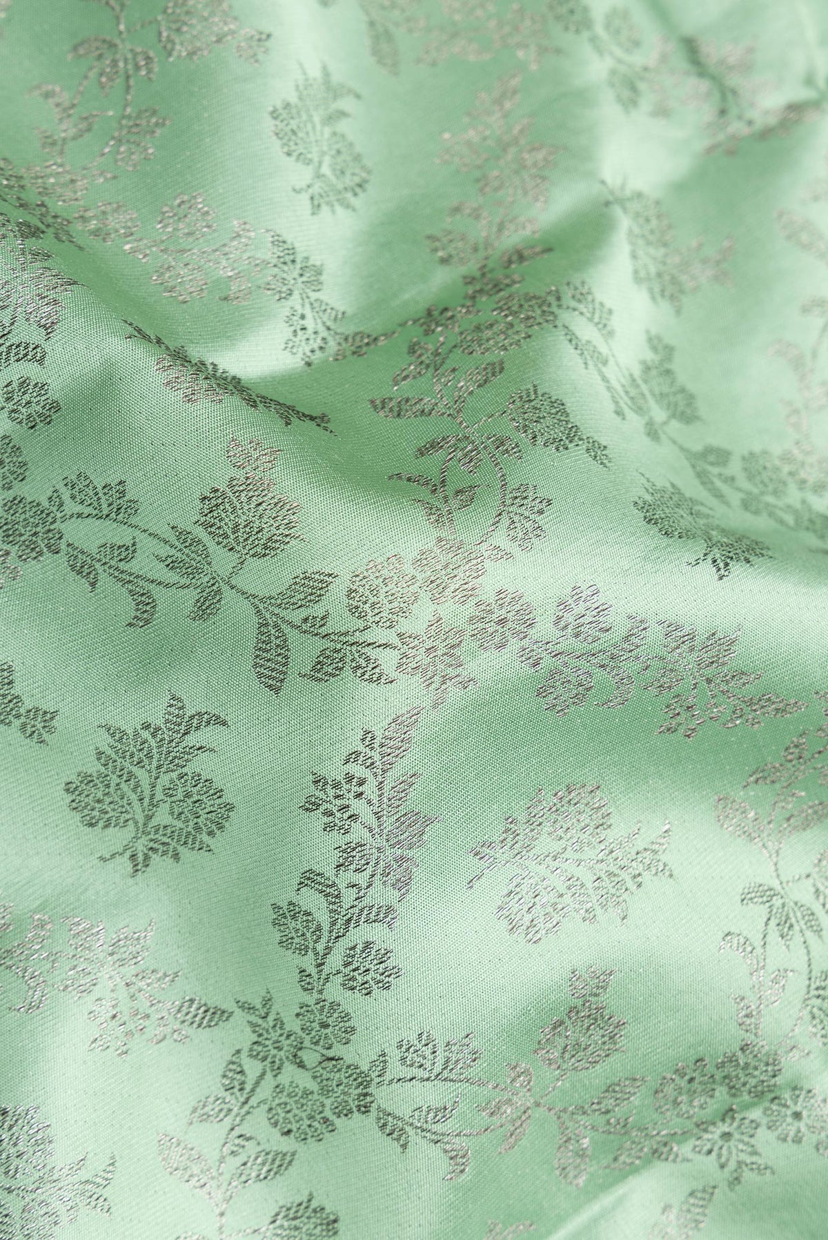 Close up of Pure Silk Pista Green Kanjivaram Saree with Zari Brocade on the body and Fancy Border.  displaying folds
