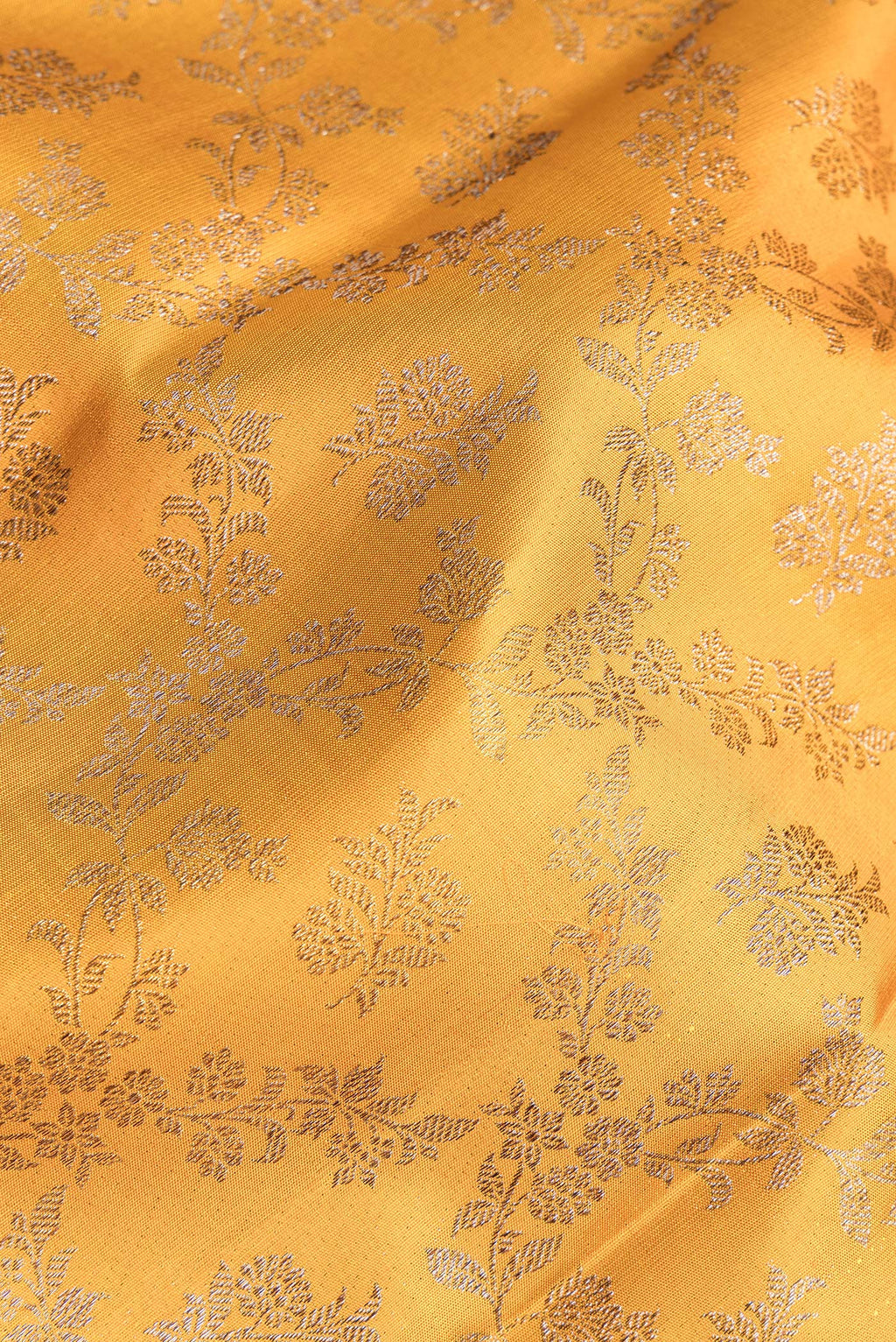 Close up of Pure Silk Mustard Kanjivaram Saree with Zari Brocade on the body and Fancy Border.  displaying folds