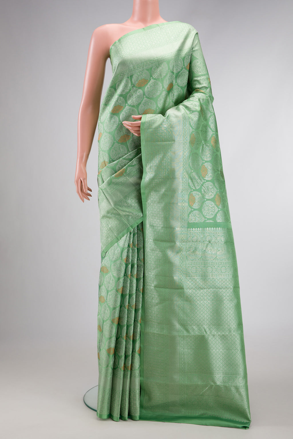 Light Green Dual Tone Kanchipuram Silk Saree with Zari Brocade on the body and Zari Border.  displayed on a mannequin