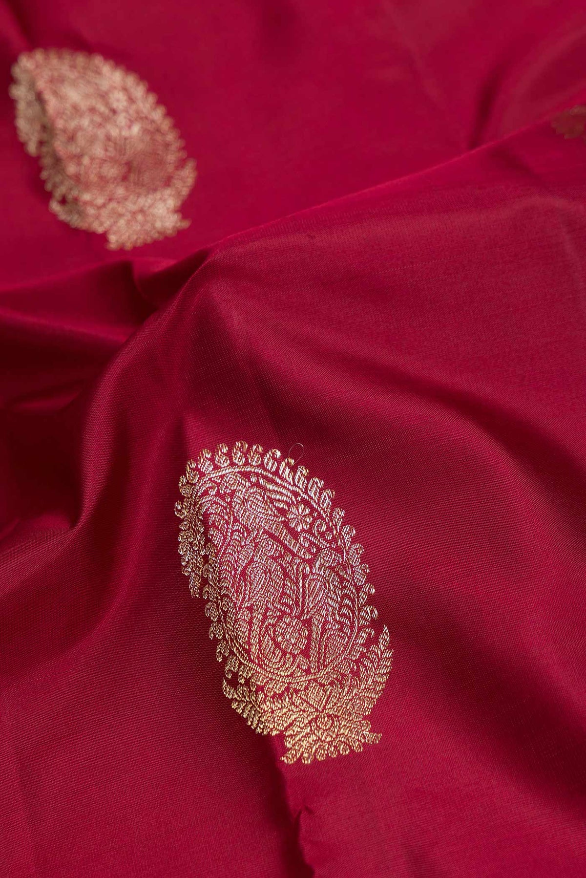 Close up of Maroon Dual Tone Kanchipuram Saree with Zari Butta on the body and Fancy Border displaying folds