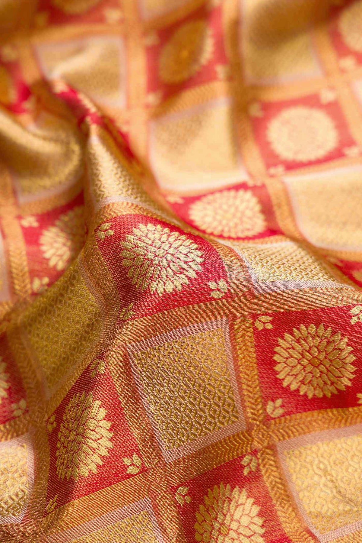 Close up of Red Dual Tone Kanchipuram Tissue Silk Saree with Zari Brocade on the body and Zari Border.  displaying folds