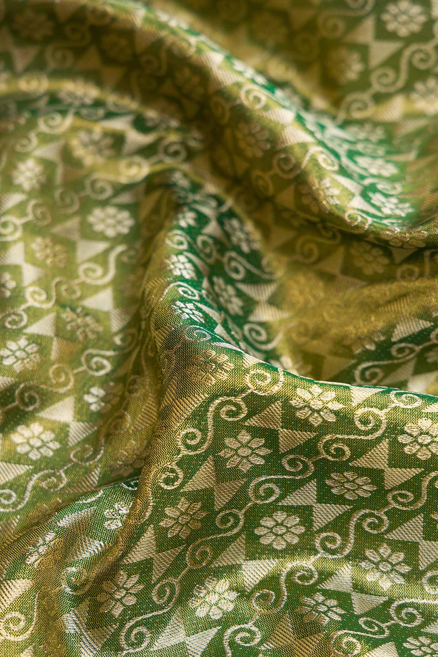 Close up of Green Dual Tone Kanchipuram Tissue Silk Saree with Zari Brocade on the body and Zari Border.  displaying folds