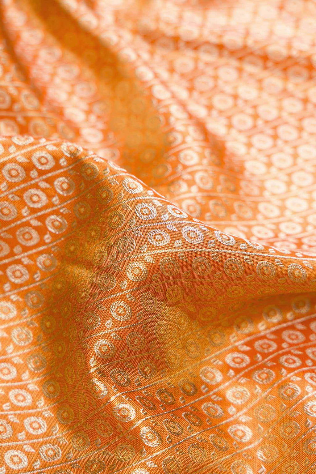 Close up of Golden Peach Dual Tone Kanchipuram Tissue Silk Saree with Zari Brocade on the body and Zari Border.  displaying folds