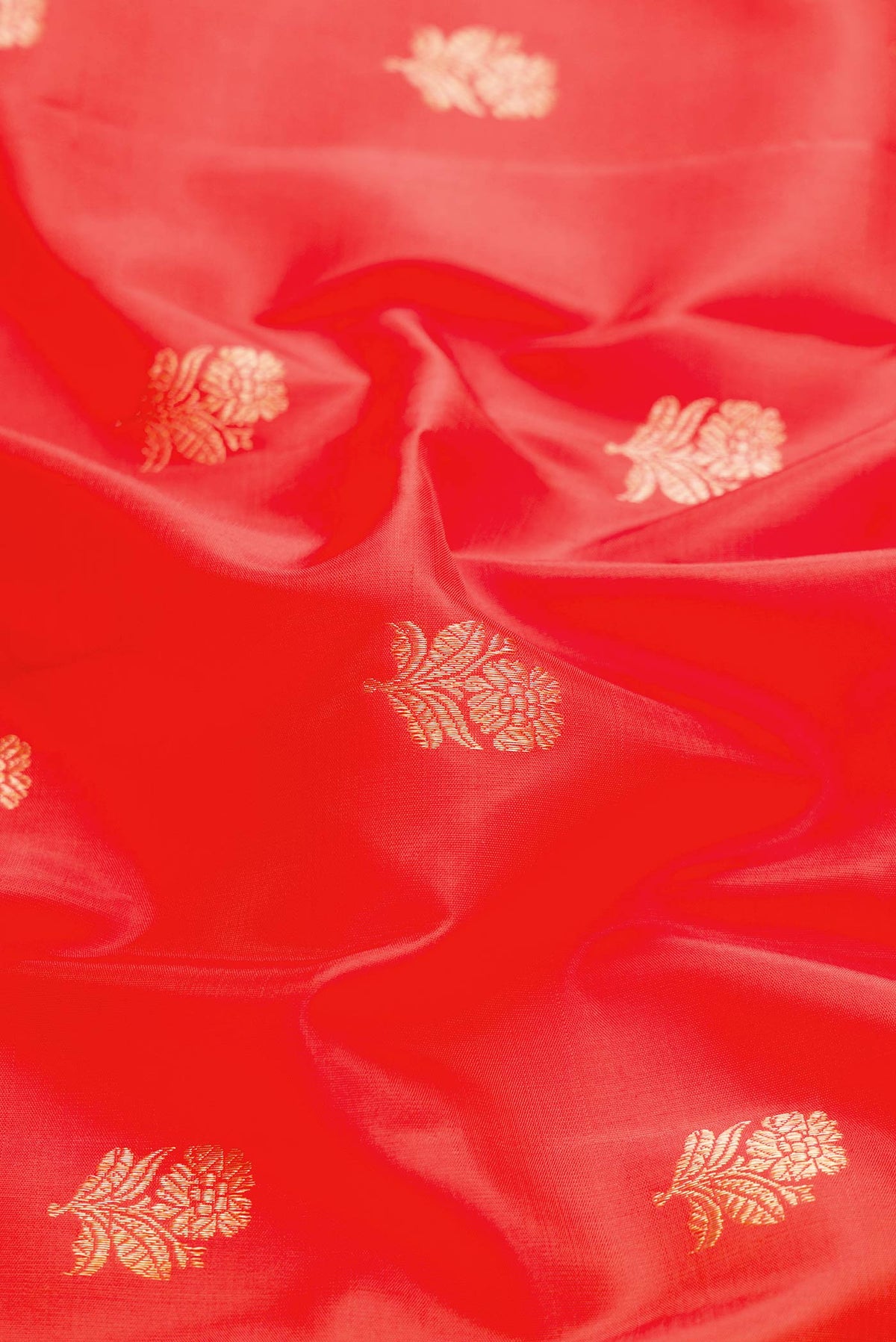 Close up of Orange Dual Tone Kanchipuram Silk Saree with Zari Butta on the body and Zari Border displaying folds