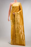 Mustard Kanchipuram Silk Saree with Zari Brocade on the body and Zari Border.  displayed on a mannequin
