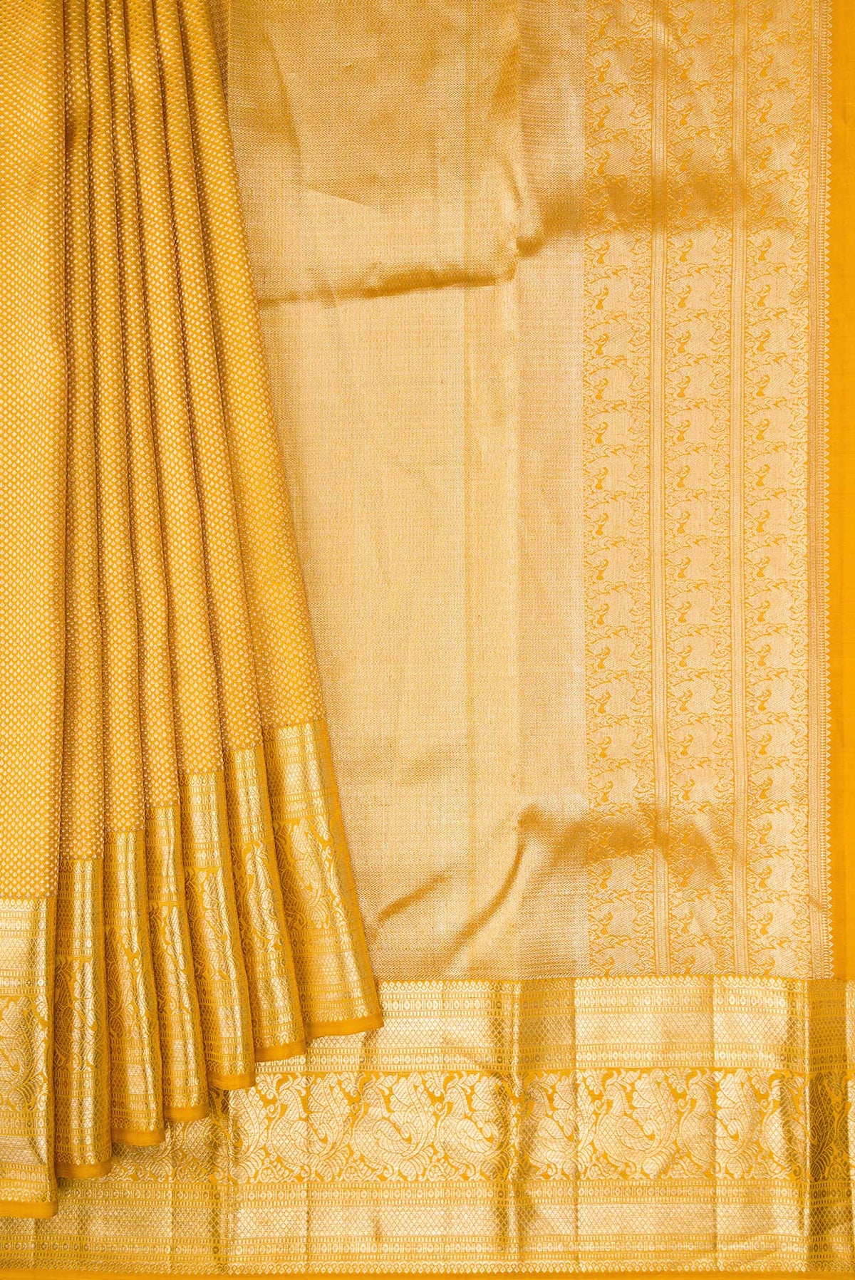 Pleats and pallu of Mustard Kanchipuram Silk Saree with Zari Brocade on the body and Zari Border. 