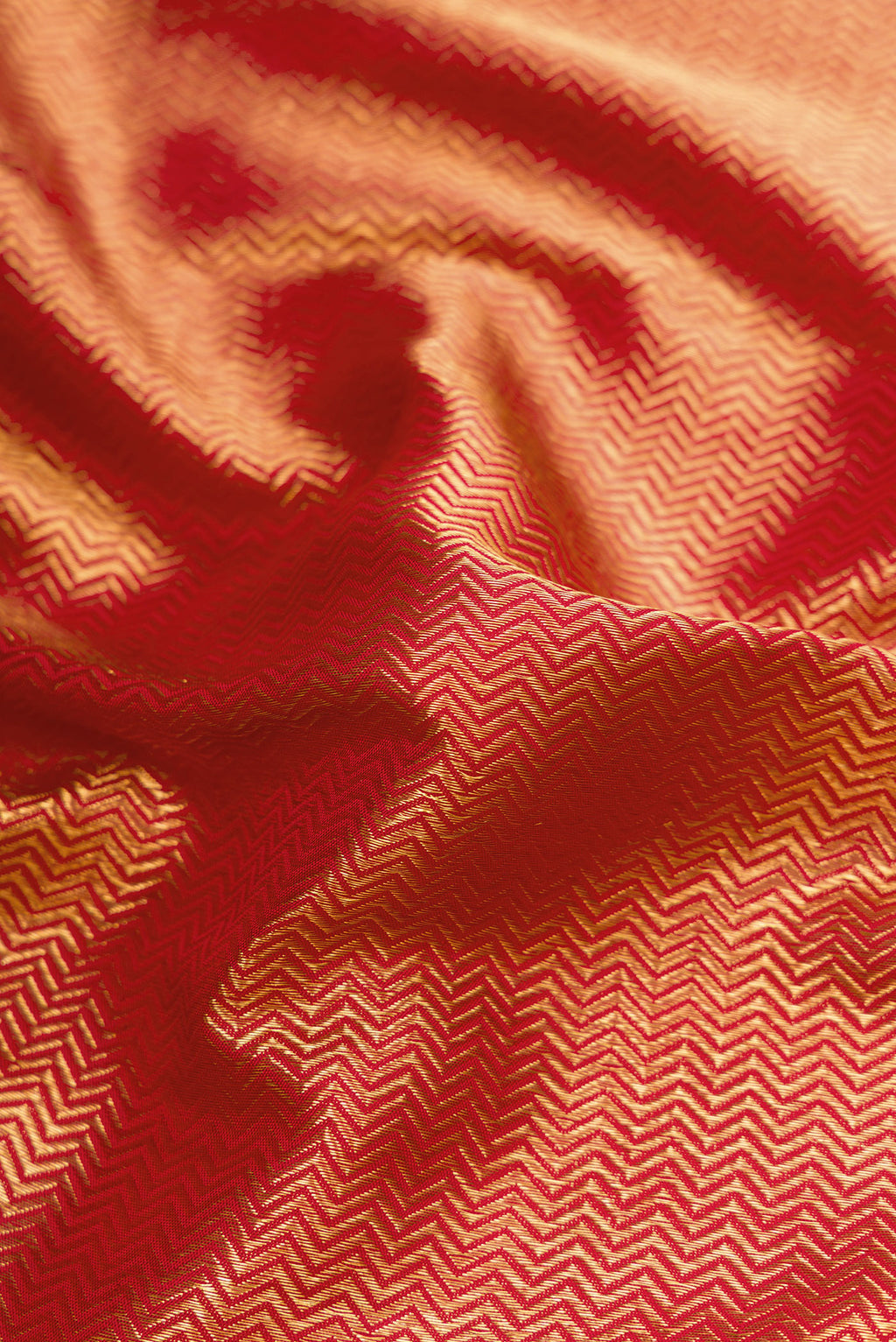 Close up of Red Dual Tone Kanchipuram Silk Saree with Zari Brocade on the body and Zari Border.  displaying folds