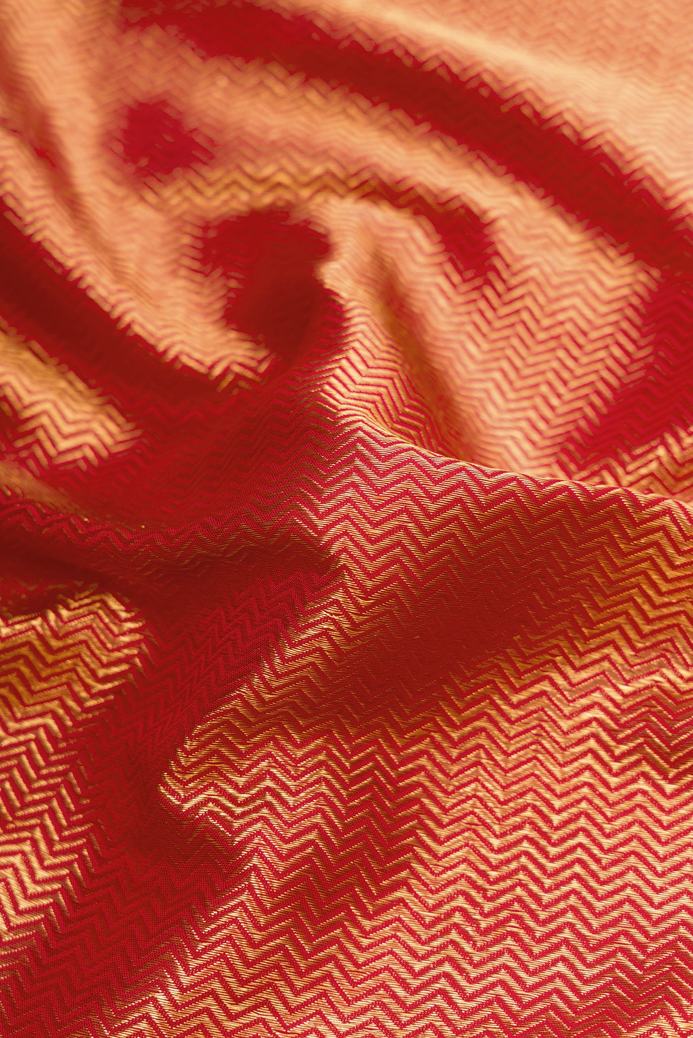 Close up of Red Dual Tone Kanchipuram Silk Saree with Zari Brocade on the body and Zari Border.  displaying folds