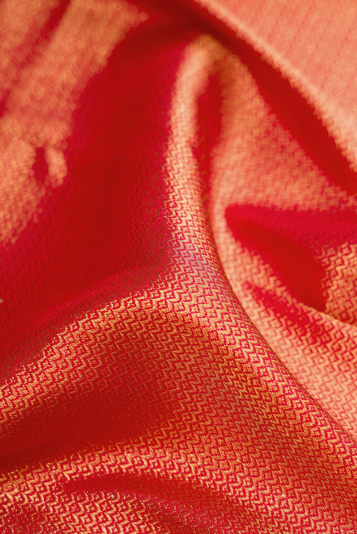 Close up of Red Kanchipuram Silk Saree with Zari Brocade on the body and Zari Border.  displaying folds