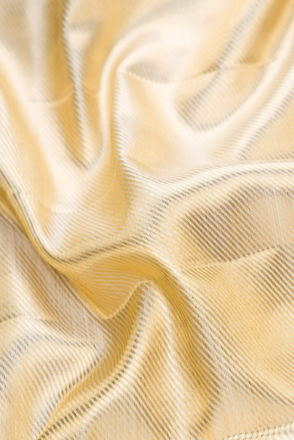Close up of Gold Dual Tone Kanjivaram Tissue Silk Saree with Zari Brocade on the body and Temple Border.  displaying folds