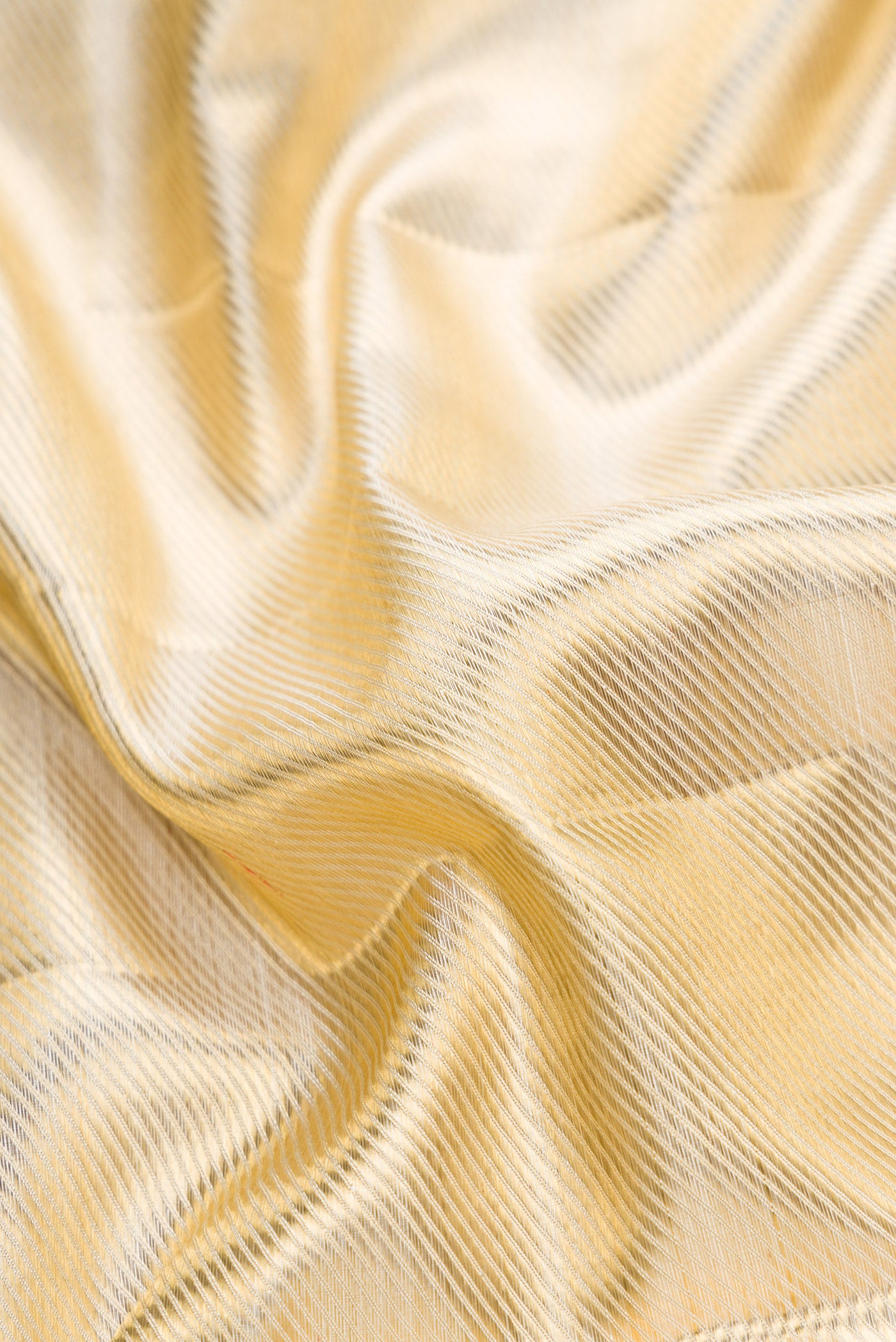 Close up of Gold Dual Tone Kanjivaram Tissue Silk Saree with Zari Brocade on the body and Temple Border.  displaying folds