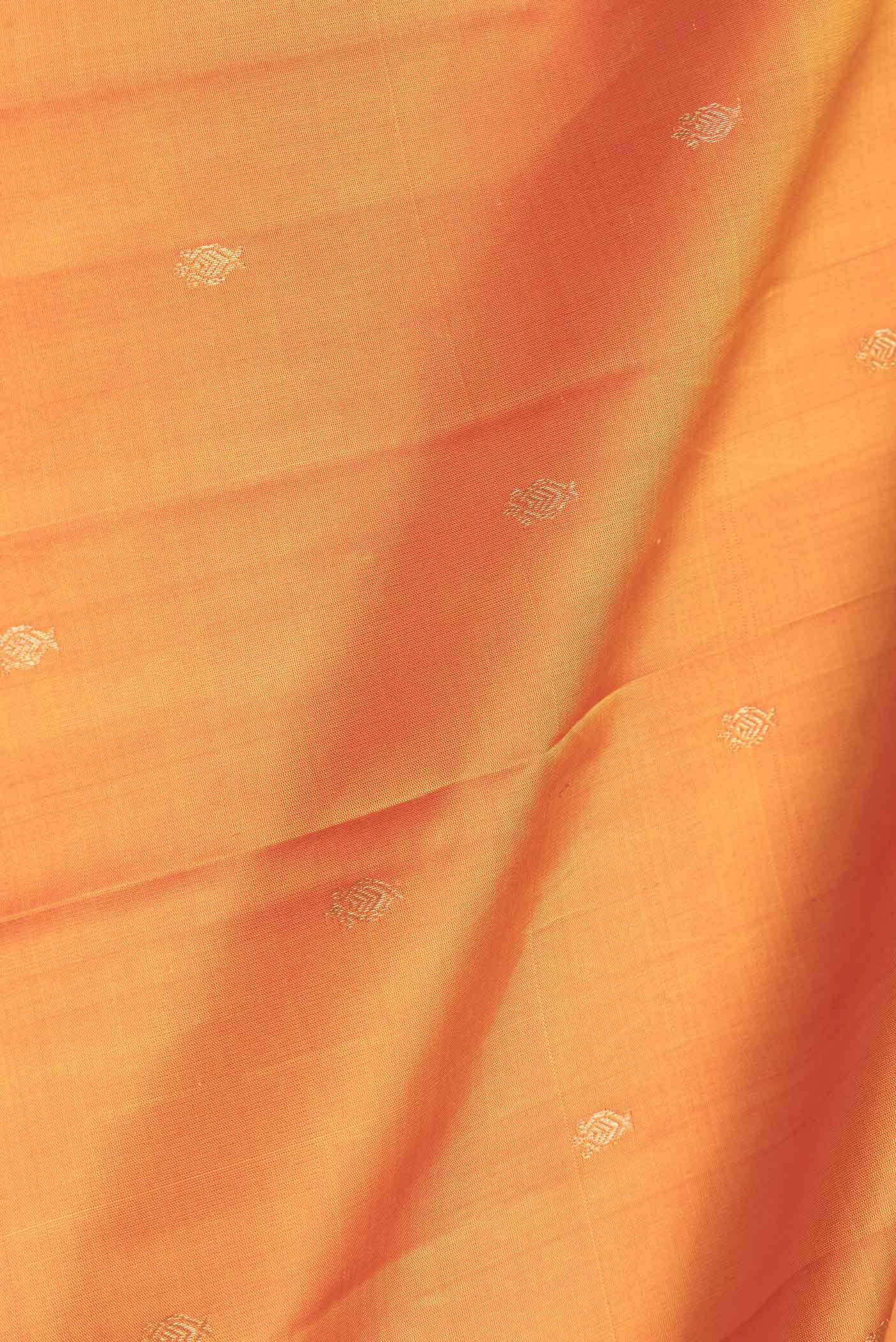 Close up of Mustard Dual Tone Kanchipuram Saree with Zari Butta on the body and Thread Border.  displaying folds