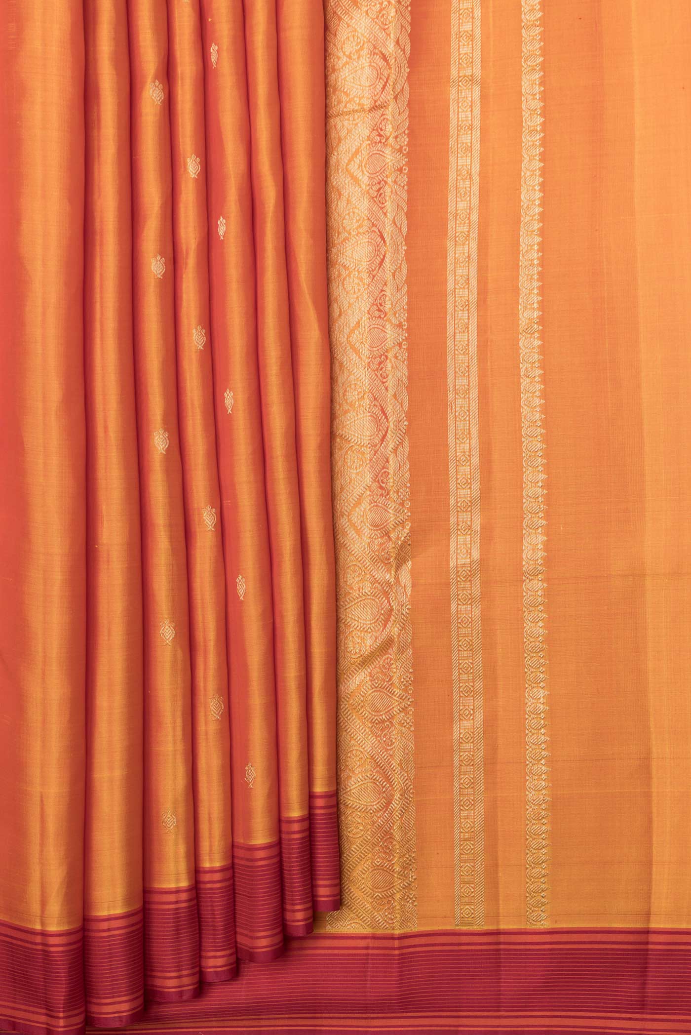 Pleats and pallu of Mustard Dual Tone Kanchipuram Saree with Zari Butta on the body and Thread Border. 