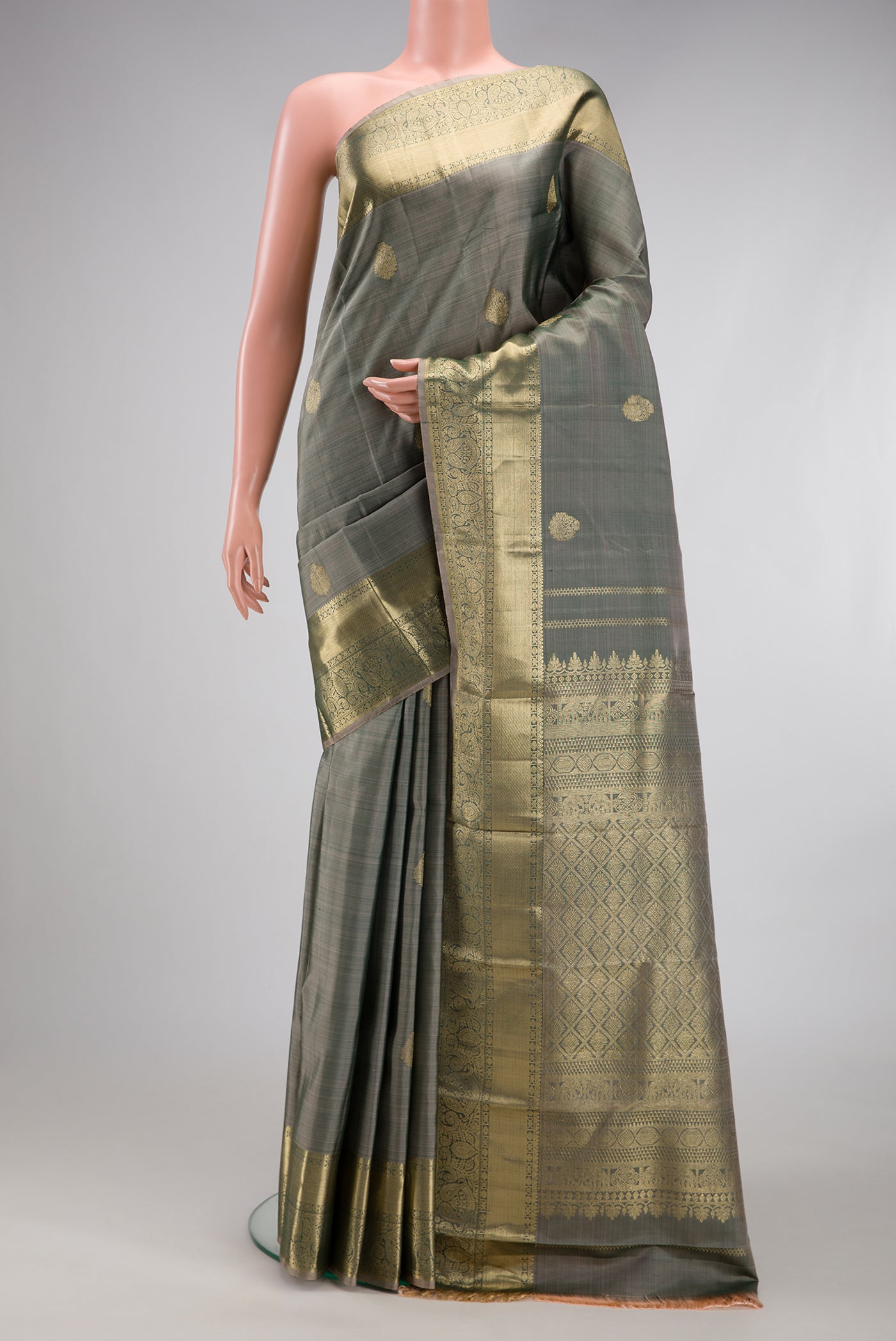 Grey Kanchipuram Silk Saree with Zari Butta on the body and Zari Border.  displayed on a mannequin