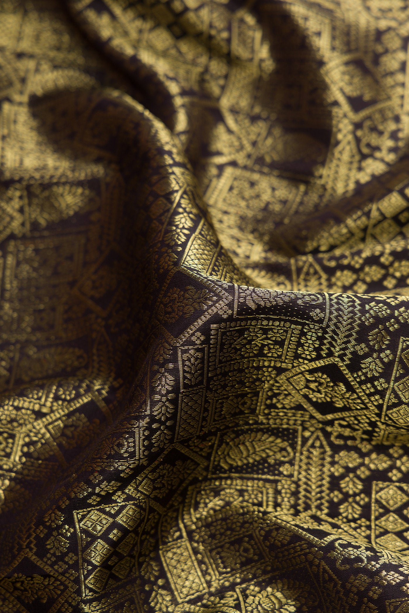 Close up of Black Dual Tone Kanjivaram Silk Saree with Zari Brocade on the body and Zari Border.  displaying folds