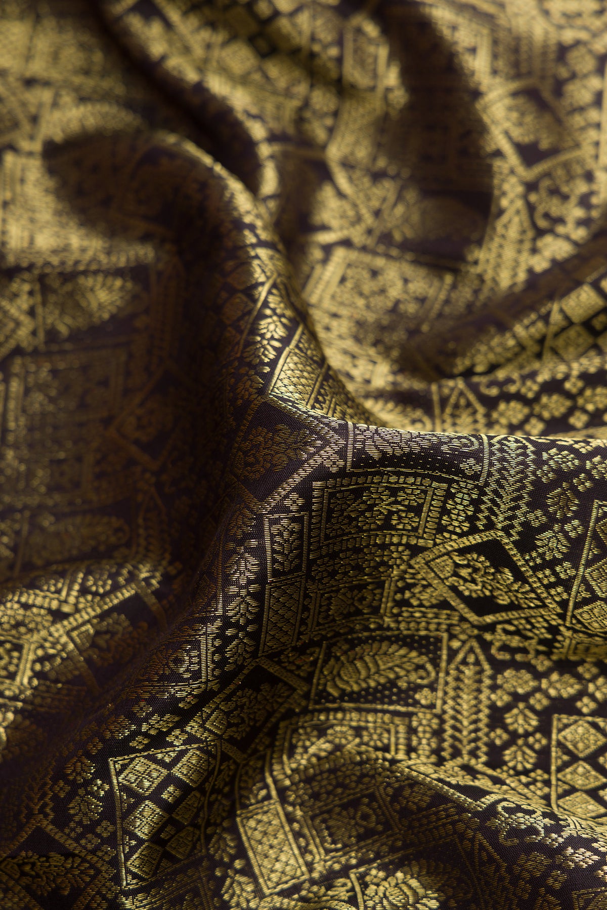 Close up of Black Dual Tone Kanjivaram Silk Saree with Zari Brocade on the body and Zari Border.  displaying folds