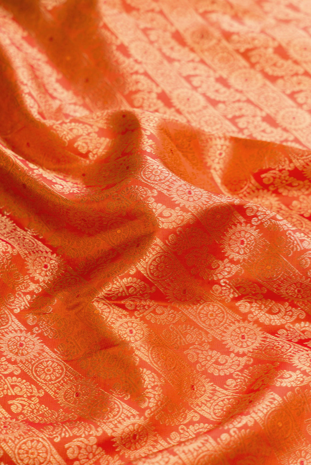Close up of Orange Dual Tone Kanjivaram Silk Saree with Zari Brocade on the body and Zari Border.  displaying folds