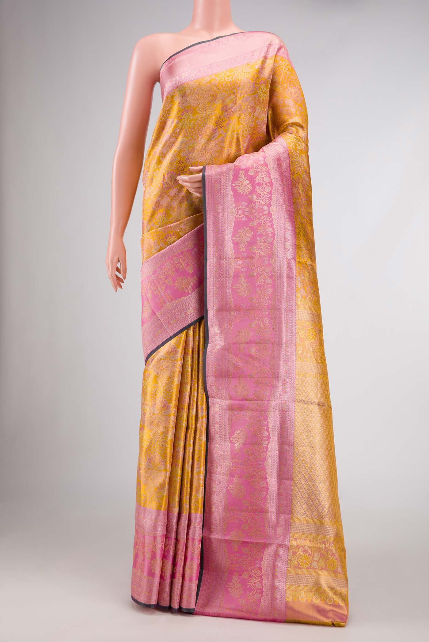Gold Dual Tone Kanjivaram Tissue Silk Saree with Zari Brocade on the body and Zari Border.  displayed on a mannequin