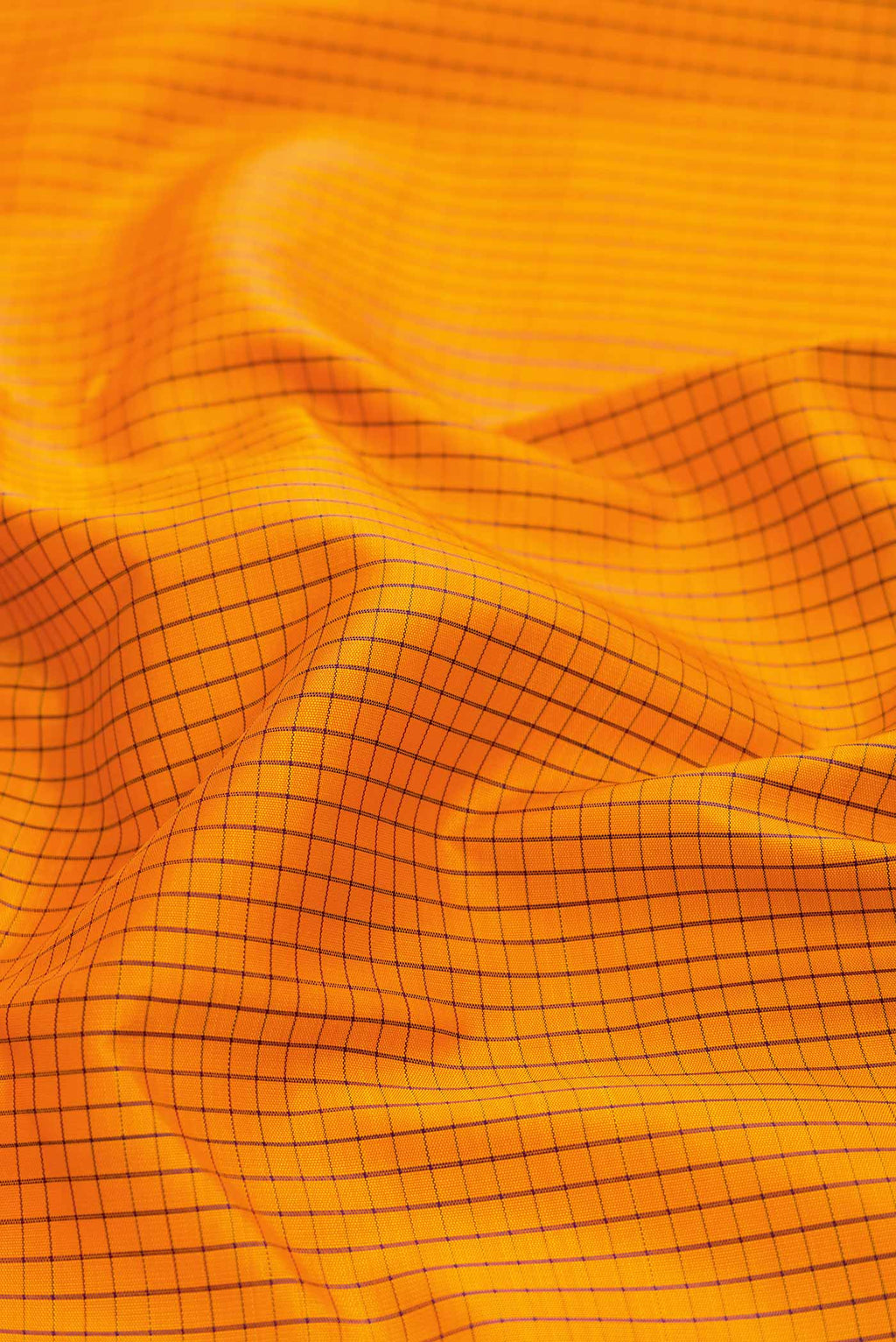 Close up of Mustard Dual Tone Kanchipuram Saree with Checked design on the body and Zari Border displaying folds