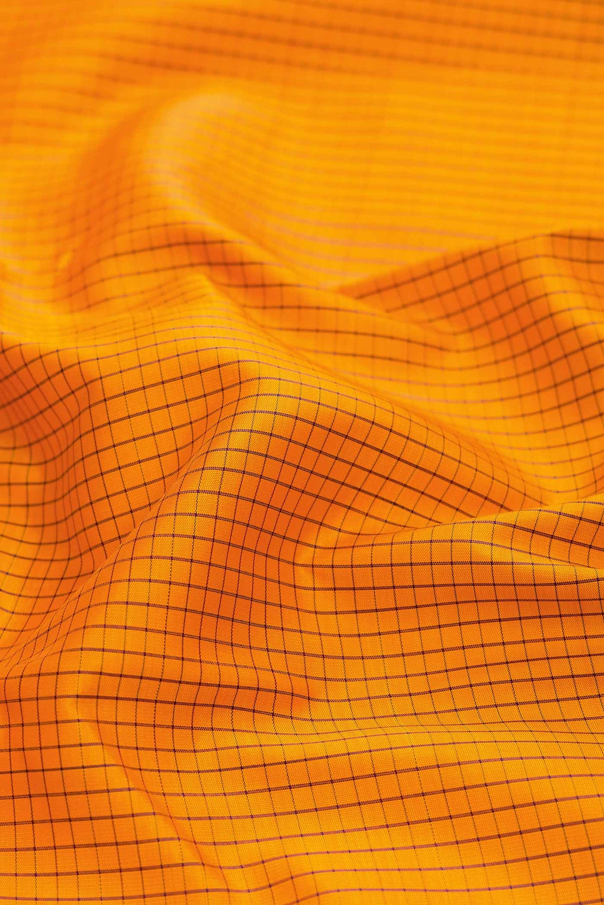 Close up of Mustard Dual Tone Kanchipuram Saree with Checked design on the body and Zari Border displaying folds