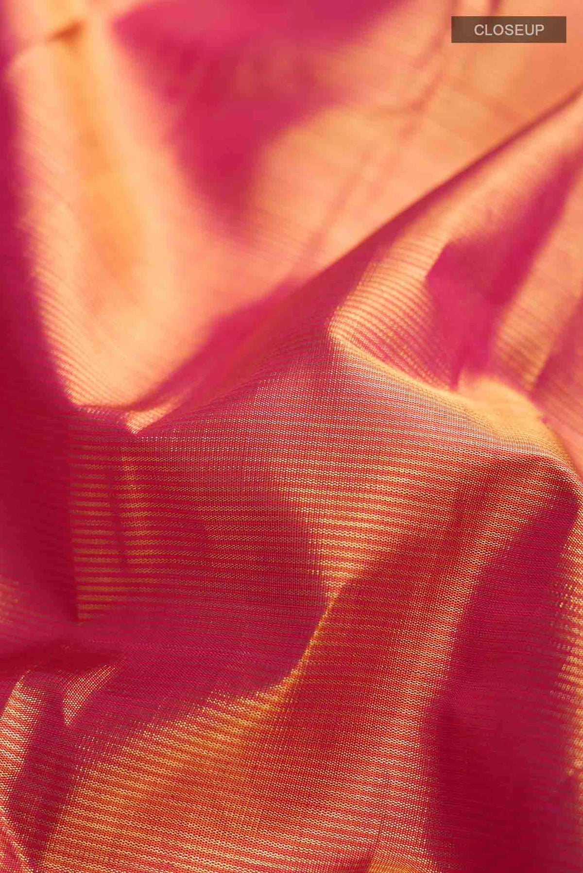 Close up of Orange Kanchipuram Silk Saree with Stripes on the body and Zari Border displaying folds