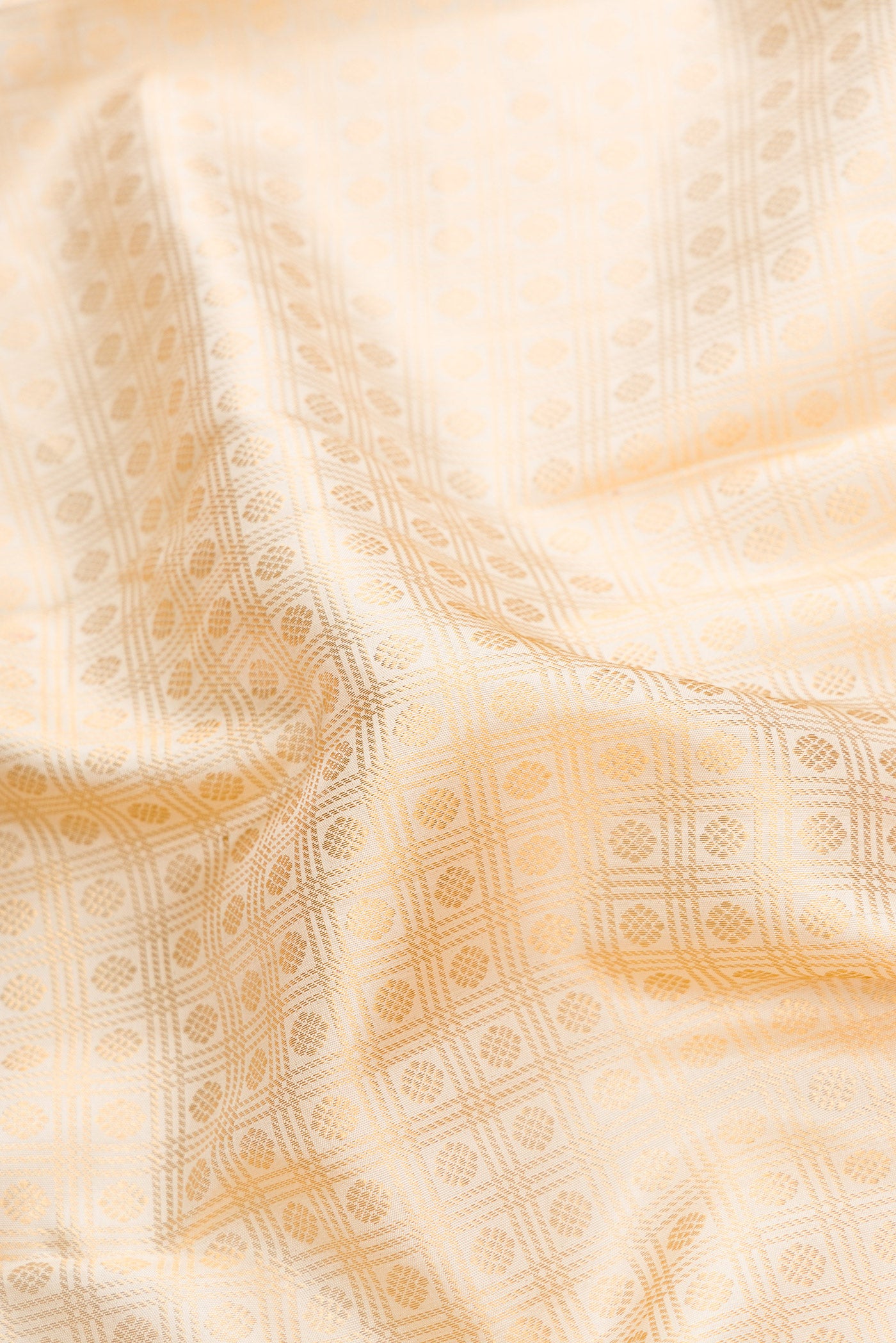 Close up of Off White Dual Tone Kanjivaram Silk Saree with Zari Brocade on the body and Zari Border.  displaying folds