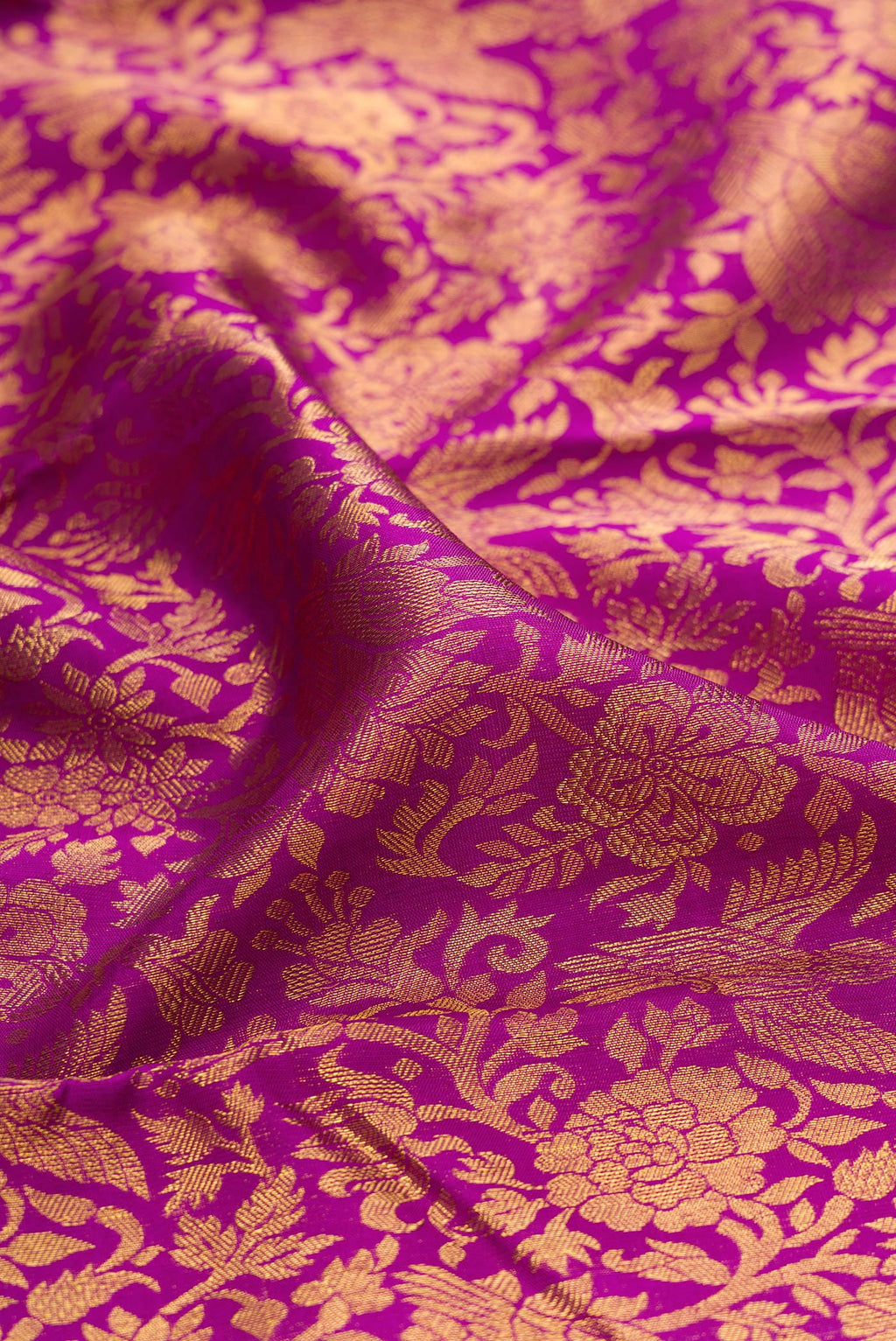 Close up of Magenta Kanjivaram Silk Saree with Zari Brocade on the body and Fancy Border.  displaying folds