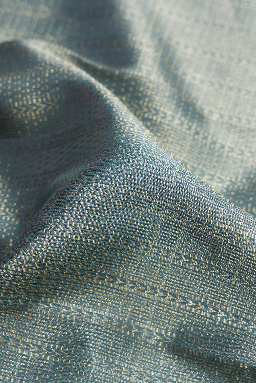 Close up of Grey Dual Tone Kanchipuram Silk Saree with Zari Brocade on the body and Zari Border.  displaying folds