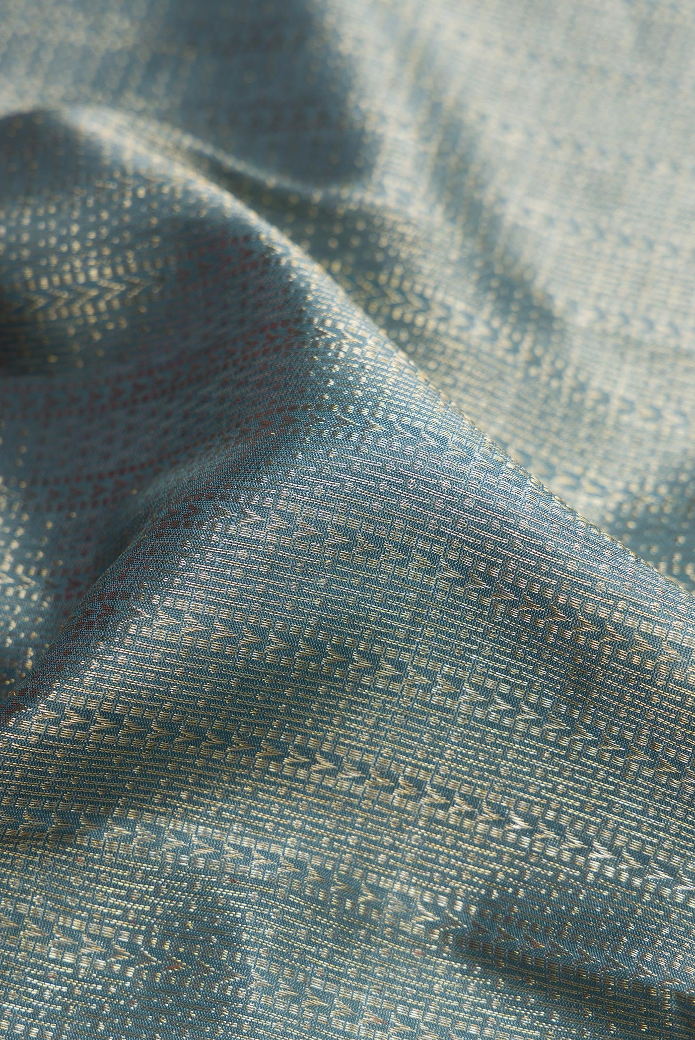 Close up of Grey Dual Tone Kanchipuram Silk Saree with Zari Brocade on the body and Zari Border.  displaying folds
