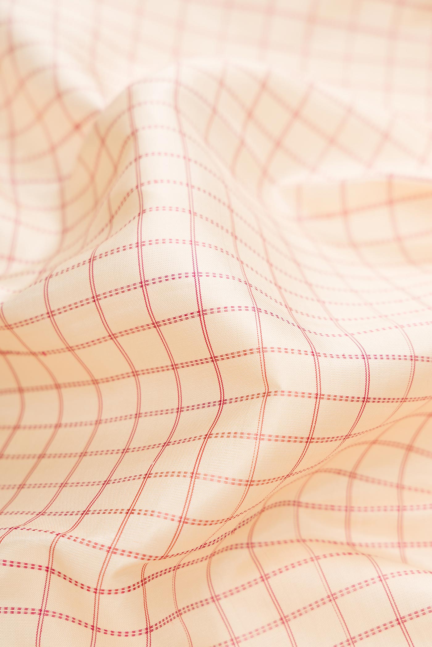 Close up of Off White Dual Tone Kanchipuram Silk Saree with Checked design on the body and Zari Border.  displaying folds