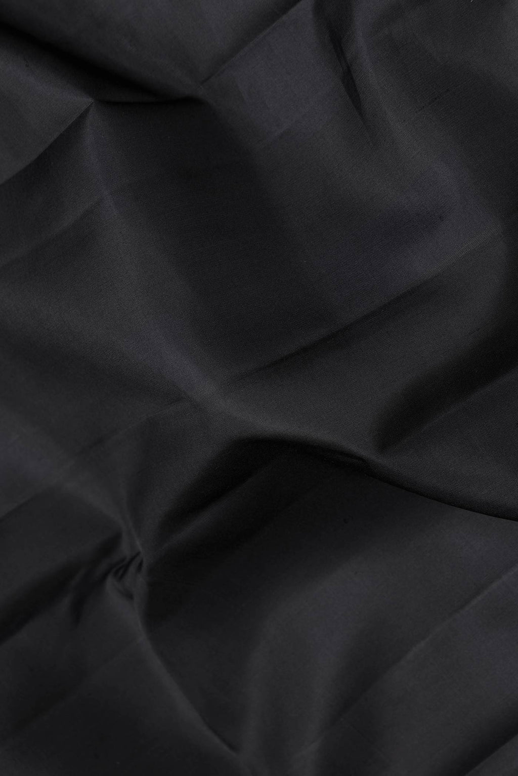 Close up of Black Dual Tone Kanchipuram Saree with Plain Body and Fancy Border.  displaying folds