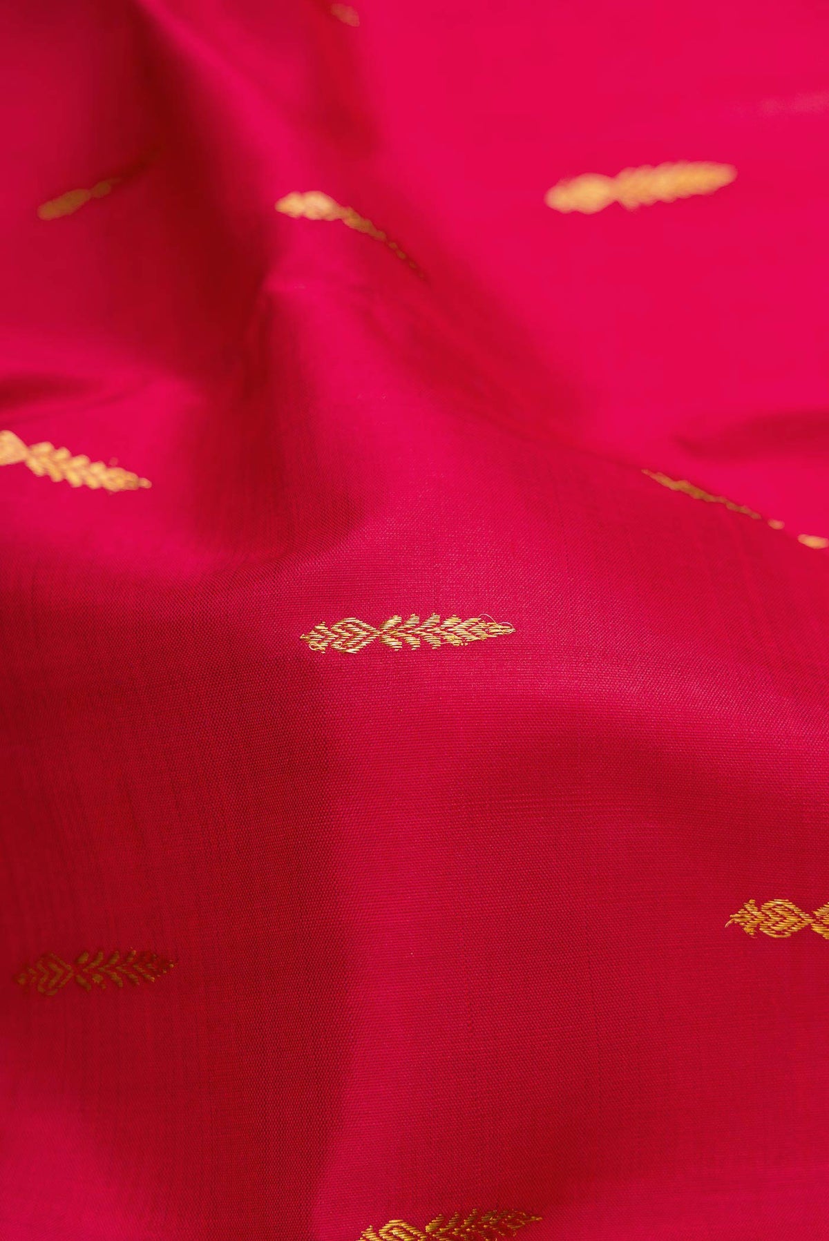 Close up of Maroon Dual Tone Kanchipuram Silk Saree with Zari Butta on the body and Zari Border.  displaying folds