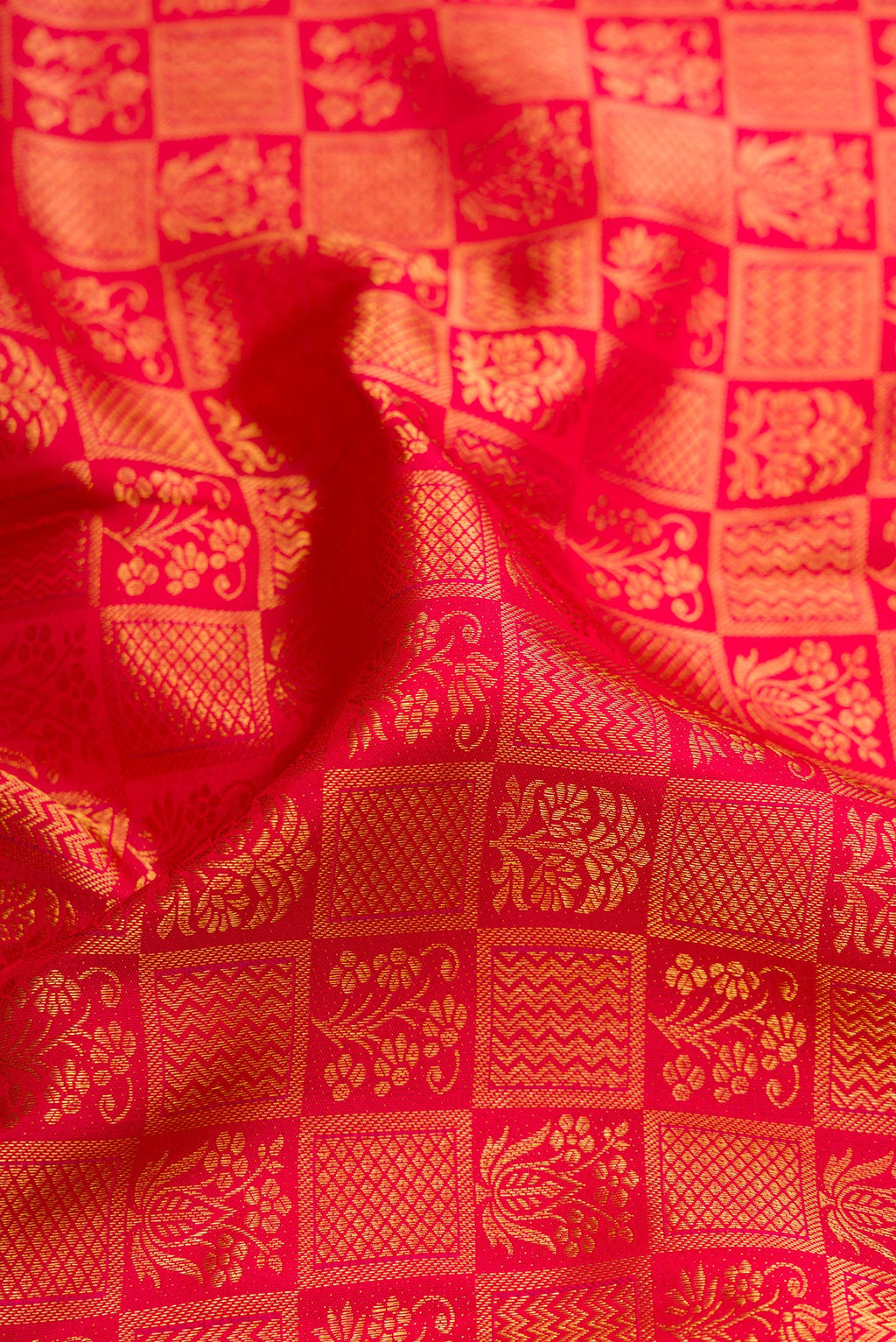 Close up of Red Kanchipuram Silk Saree with Zari Brocade on the body and Zari Border.  displaying folds