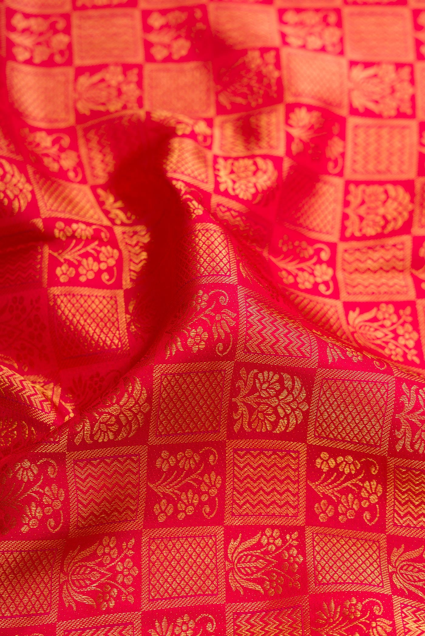 Close up of Red Kanchipuram Silk Saree with Zari Brocade on the body and Zari Border.  displaying folds