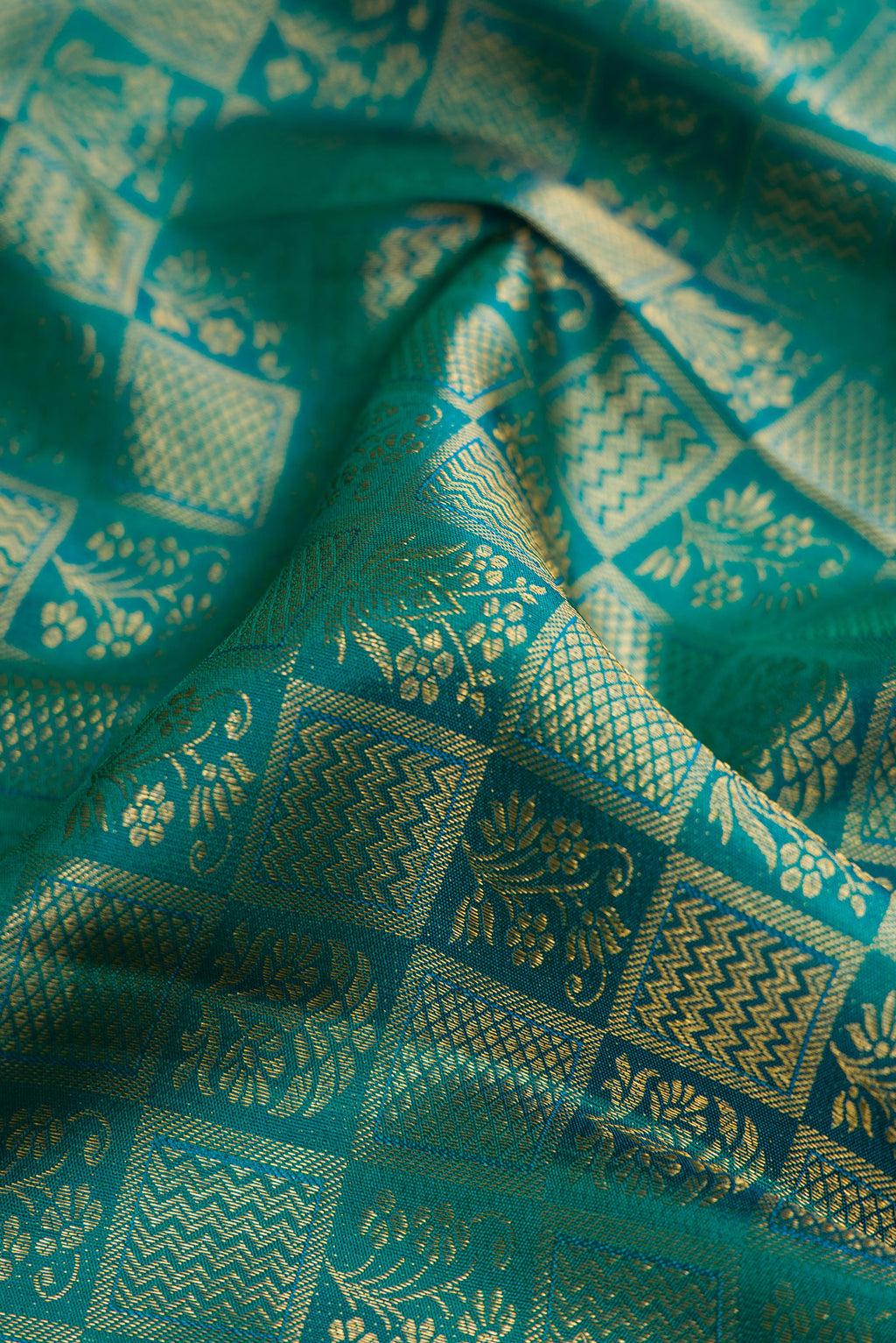 Close up of Green Kanchipuram Silk Saree with Zari Brocade on the body and Zari Border.  displaying folds