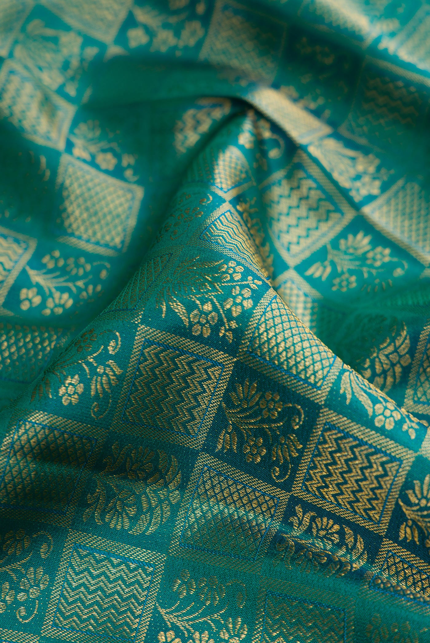 Close up of Green Kanchipuram Silk Saree with Zari Brocade on the body and Zari Border.  displaying folds