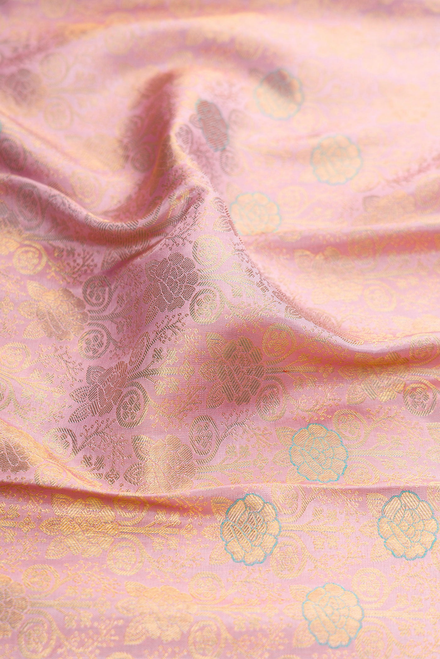 Close up of Rose Gold Dual Tone Kanchipuram Silk Saree with Zari Brocade on the body and Zari Border.  displaying folds