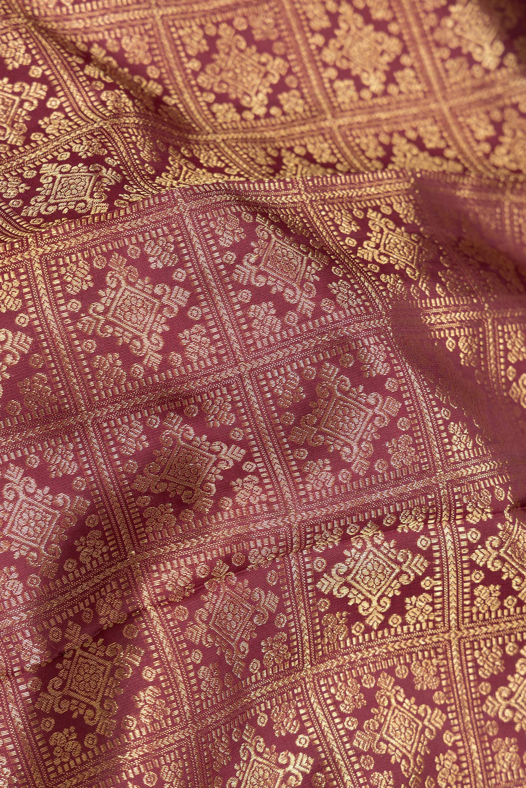 Close up of Maroon Dual Tone Kanjivaram Silk Saree with Zari Brocade on the body and Zari Border.  displaying folds