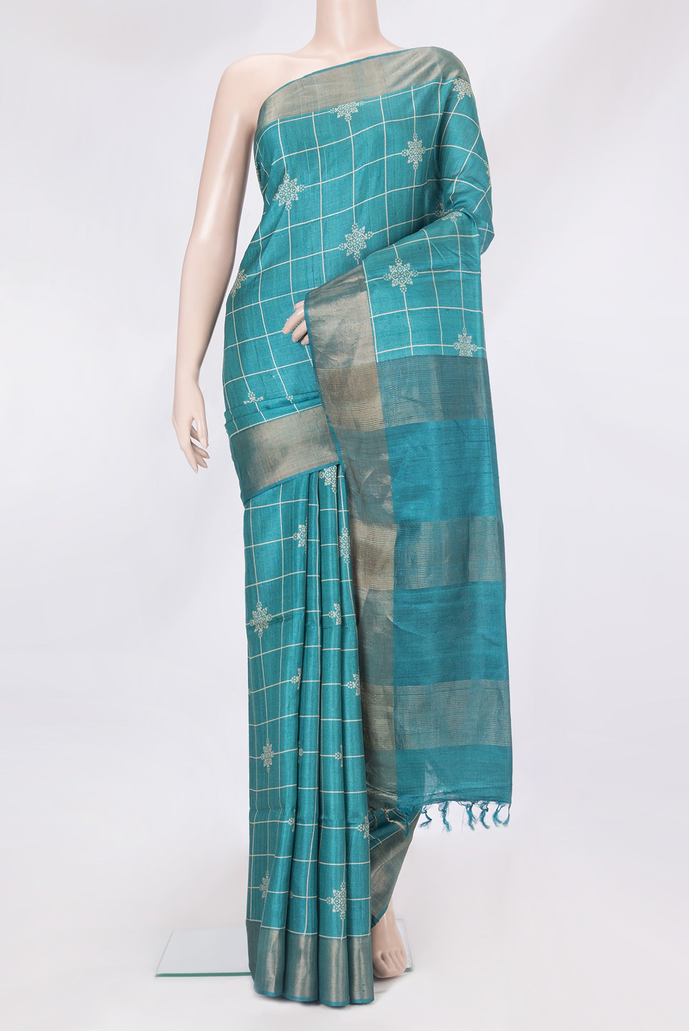 Peacock Blue Tussar Silk Saree with Checked design on the body and Zari Border.  displayed on a mannequin