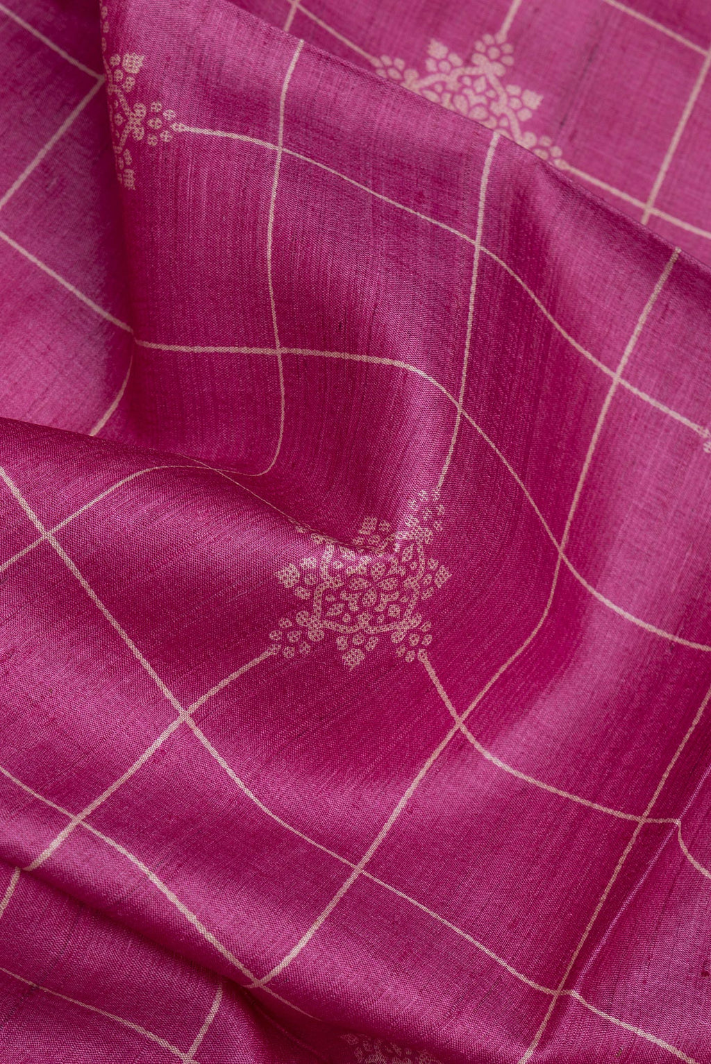 Close up of Pink Tussar Silk Saree with Checked design on the body and Zari Border.  displaying folds