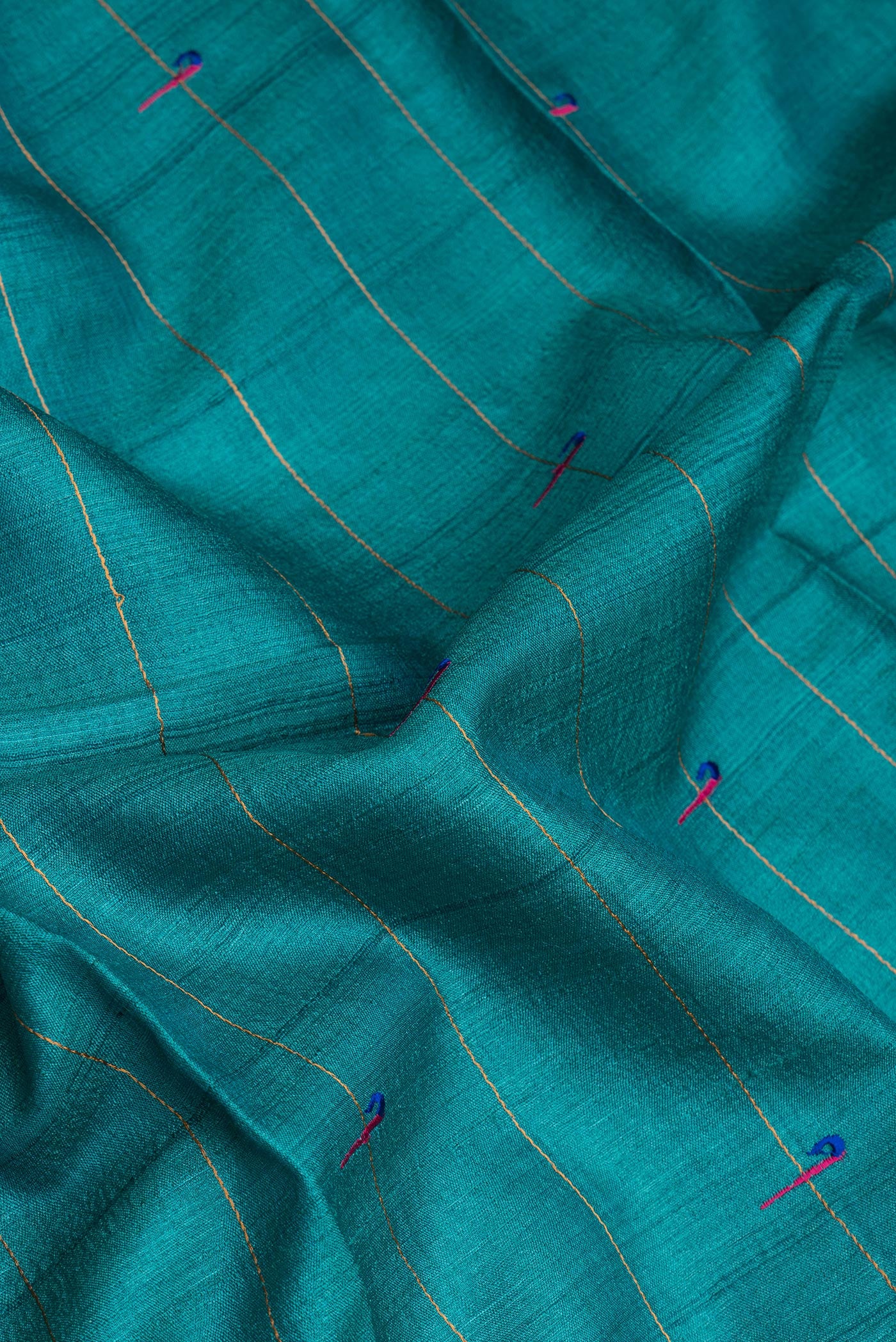Close up of Peacock Blue Tussar Silk Saree with Checked design on the body and Zari Border.  displaying folds