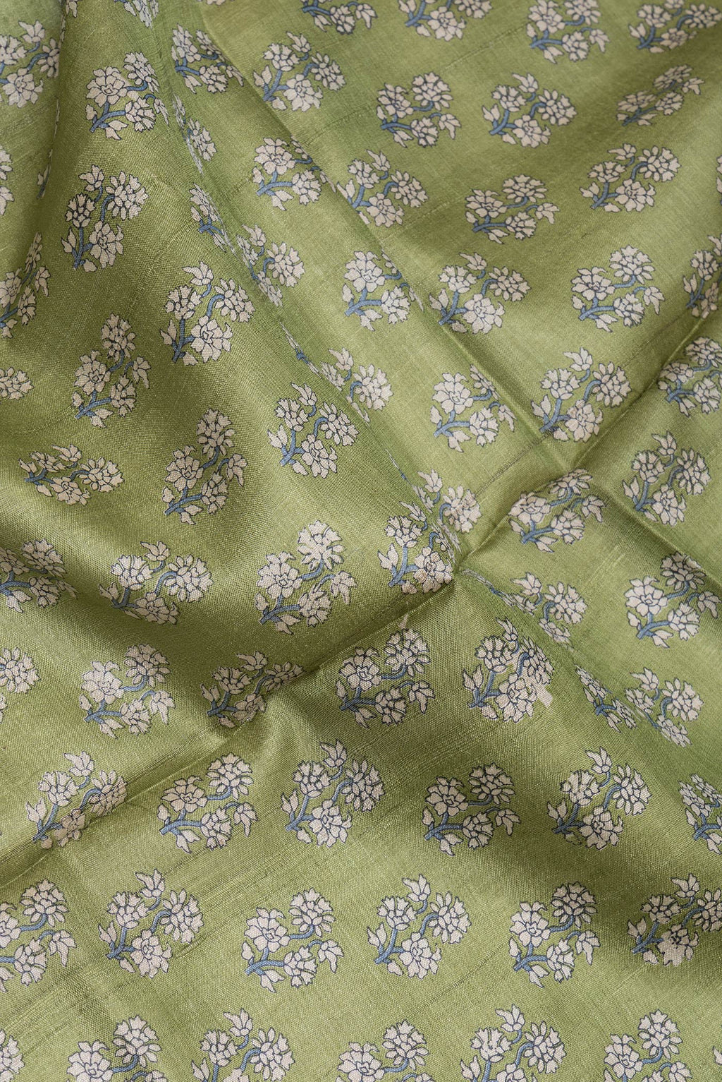 Close up of Mehandi Green Dual Tone Tussar Silk Saree with Printed design on the body and Embroidery Border.  displaying folds