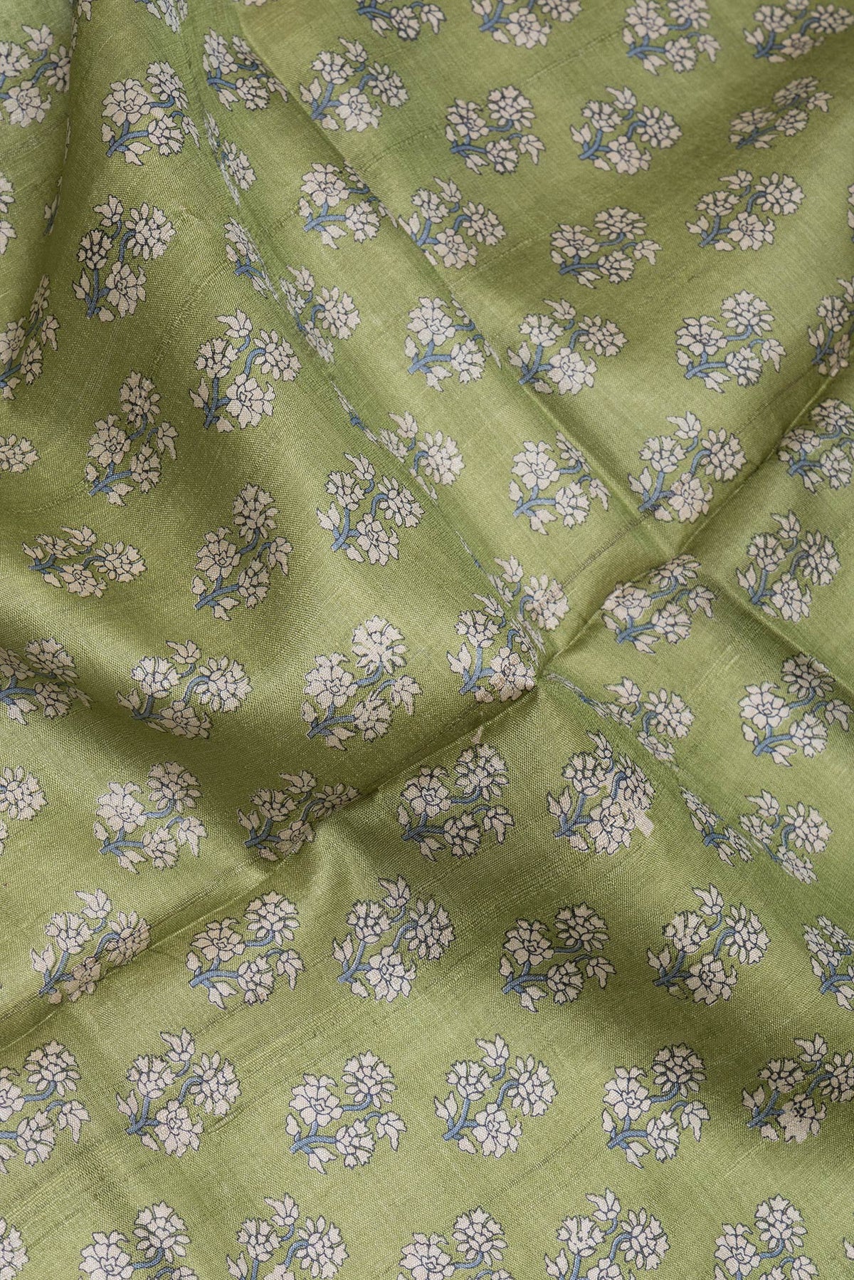Close up of Mehandi Green Dual Tone Tussar Silk Saree with Printed design on the body and Embroidery Border.  displaying folds