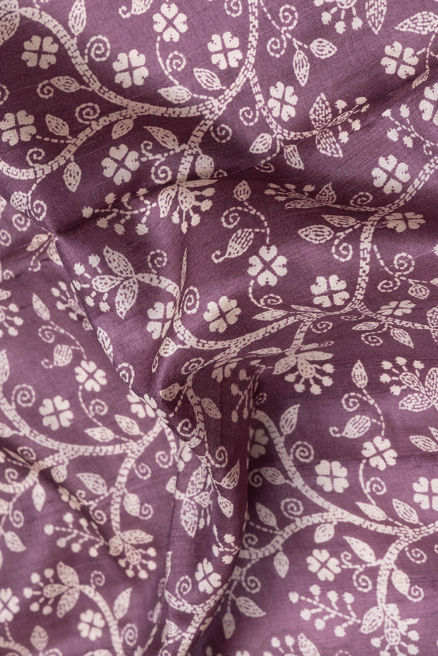 Close up of Purple Tussar Silk Saree with Printed design on the body and Embroidery Border.  displaying folds