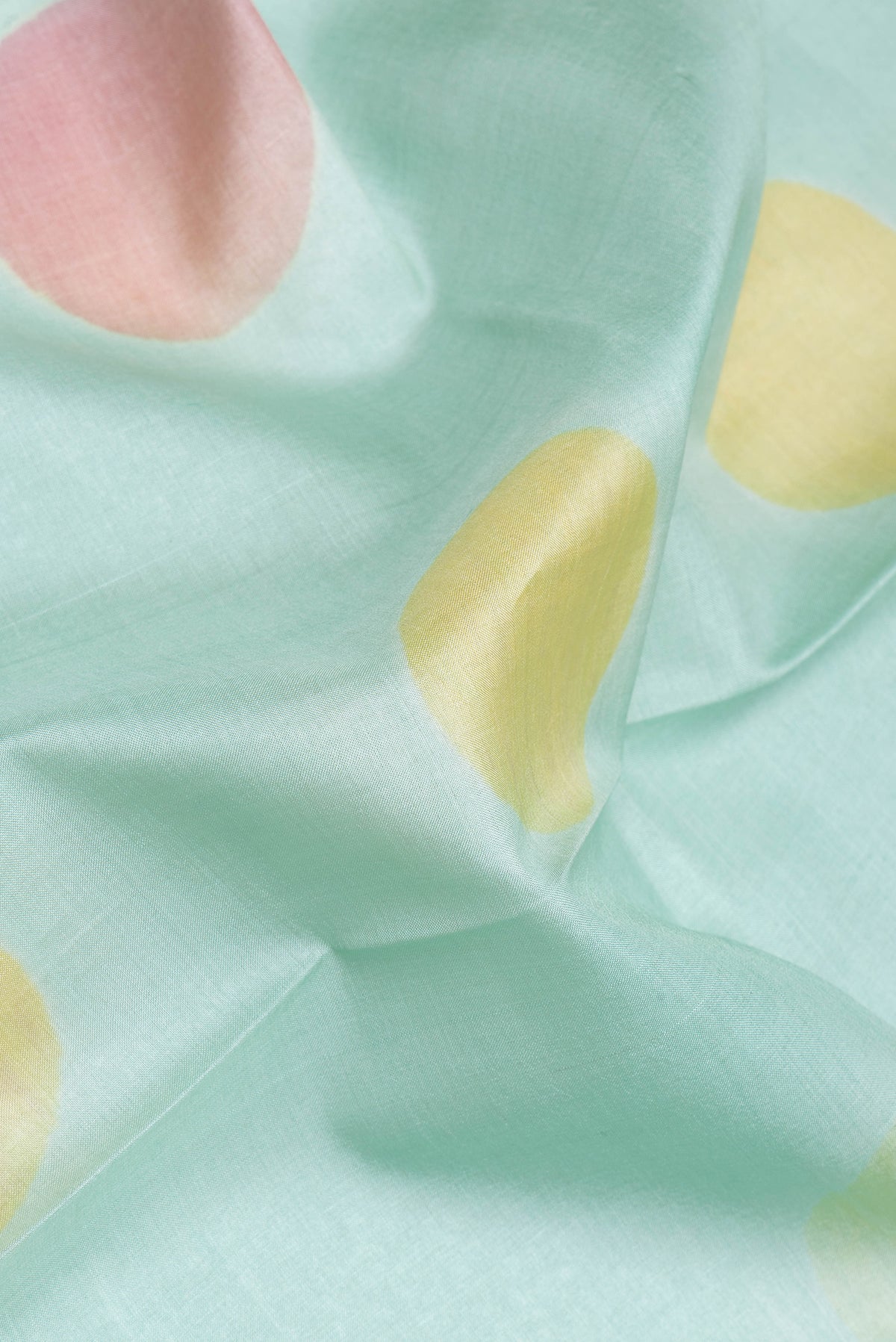 Close up of Sea Green Dual Tone Tussar Silk Saree with Printed design on the body and Without Border.  displaying folds