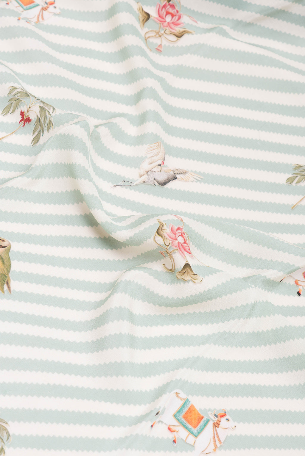 Close up of Light Blue Crepe Saree with Printed design on the body and Plain Border.  displaying folds