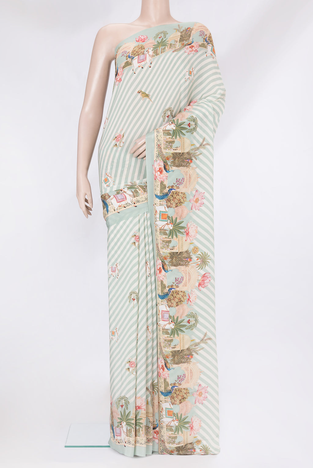 Light Blue Crepe Saree with Printed design on the body and Plain Border.  displayed on a mannequin