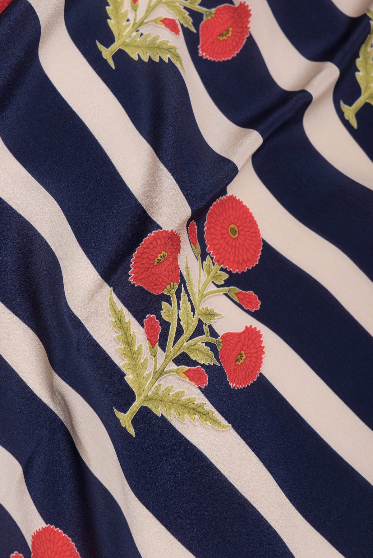 Close up of Off white and Navy Blue Color Mysore Crepe Saree with Printed design on the body and Without Border.  displaying folds