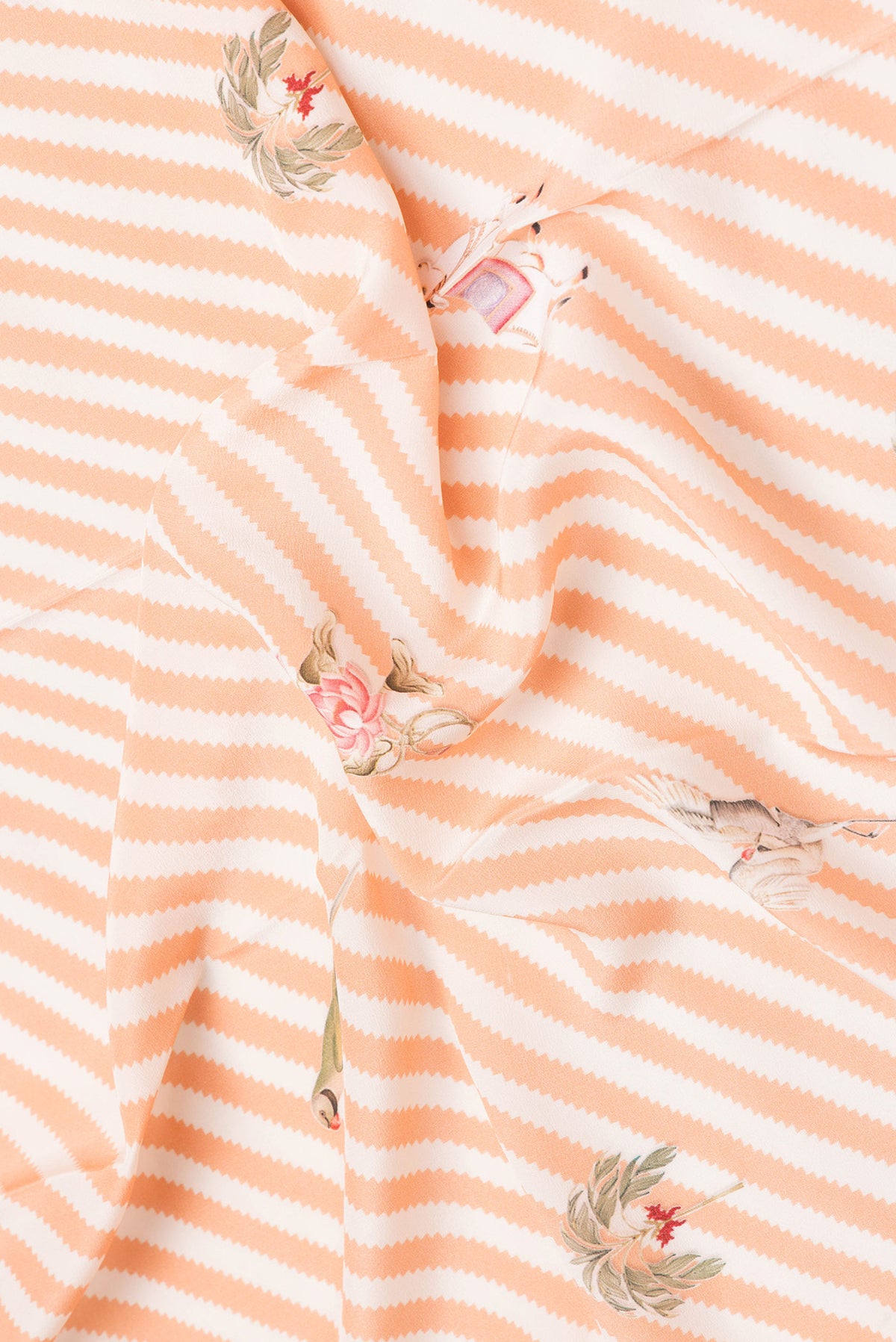 Close up of Orange Dual Tone Mysore Crepe Saree with Printed design on the body and Fancy Border.  displaying folds